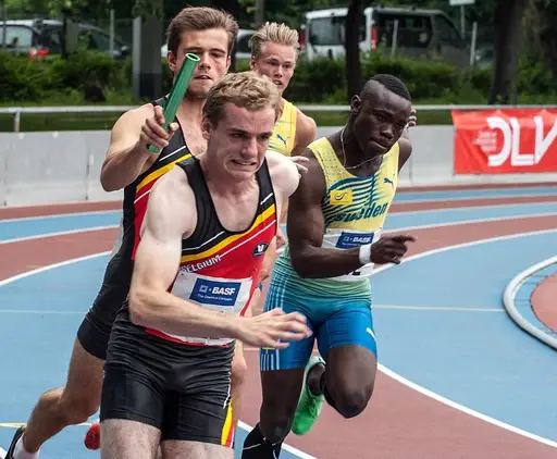 relay runner passing the baton to the teammate following him