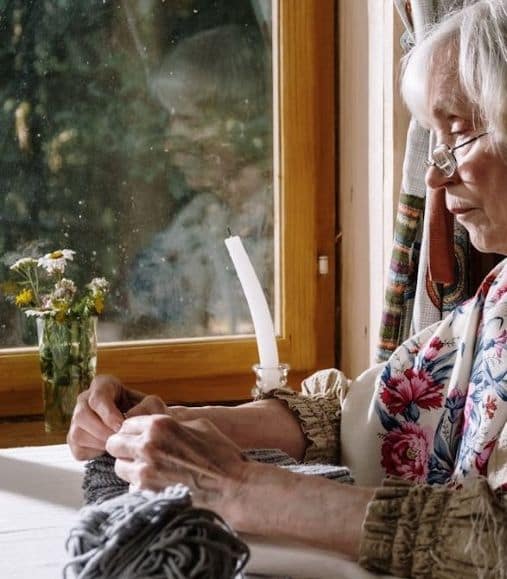woman knitting by a window