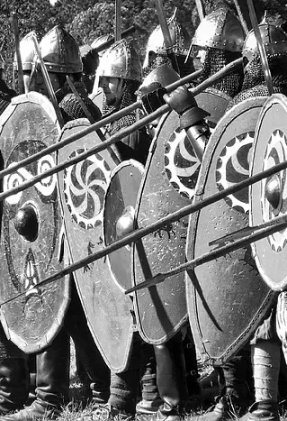 Actors dressed like soldiers from the Middle Ages, with helmets, shields, and spears.