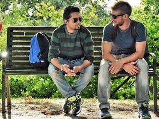 2 young men chatting on a park bench