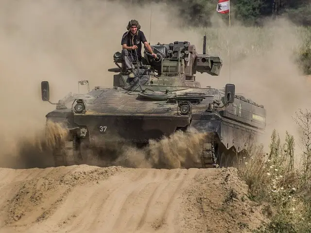old tank rolling down a dusty road